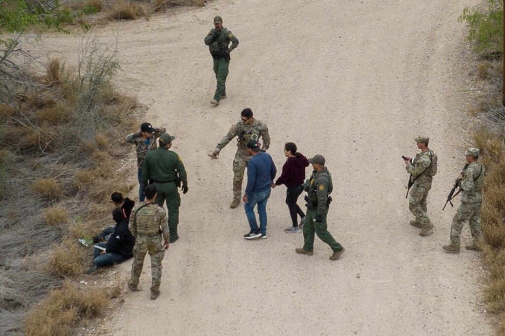 Border patrol agents and Texas Army National Guard soldiers detain migrants, who were hiding in thick brush, after they crossed the Rio Grande river into the United States from Mexico in La Joya, Texas, US, on 17th March, 2023.
