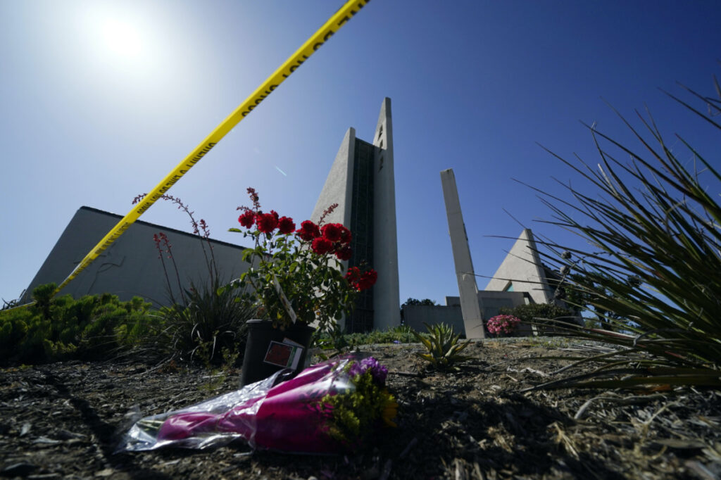 Flowers sit near crime scene tape at Geneva Presbyterian Church, on Tuesday, 17th May, 2022, in Laguna Woods, California, after a fatal shooting at the church.