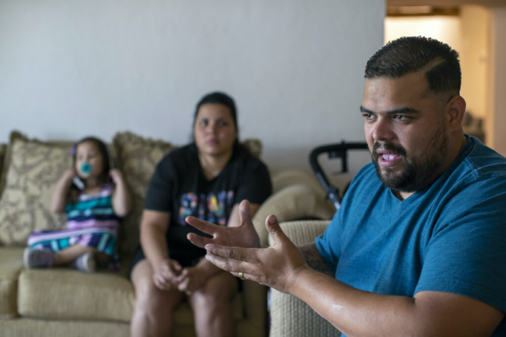 Venezuelan asylum-seeker Luis Lopez speaks with The Associated Press, as his wife, Oriana Marcano, and daughter Amaloha Lopez listen in El Paso, Texas, on Friday, 12th May, 2023.