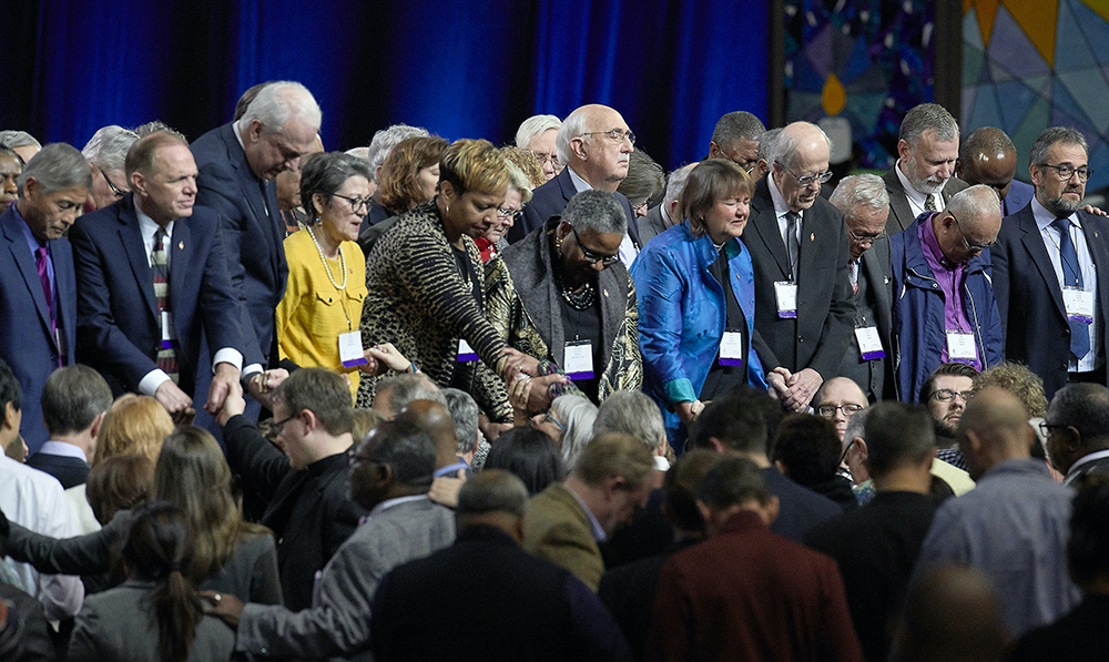 United Methodist bishops and delegates gather together to pray at the front of the stage before a key vote on church policies about homosexuality on 26th February, 2019, during the special session of the General Conference of The United Methodist Church, held in St Louis, Missouri