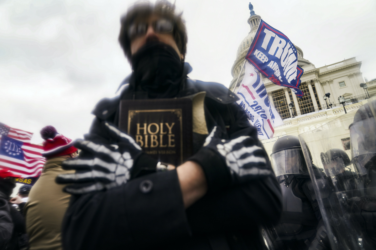 In this Wednesday, 6th January, 2021 file photo, a man holds a Bible as Trump supporters gather outside the Capitol in Washington. 