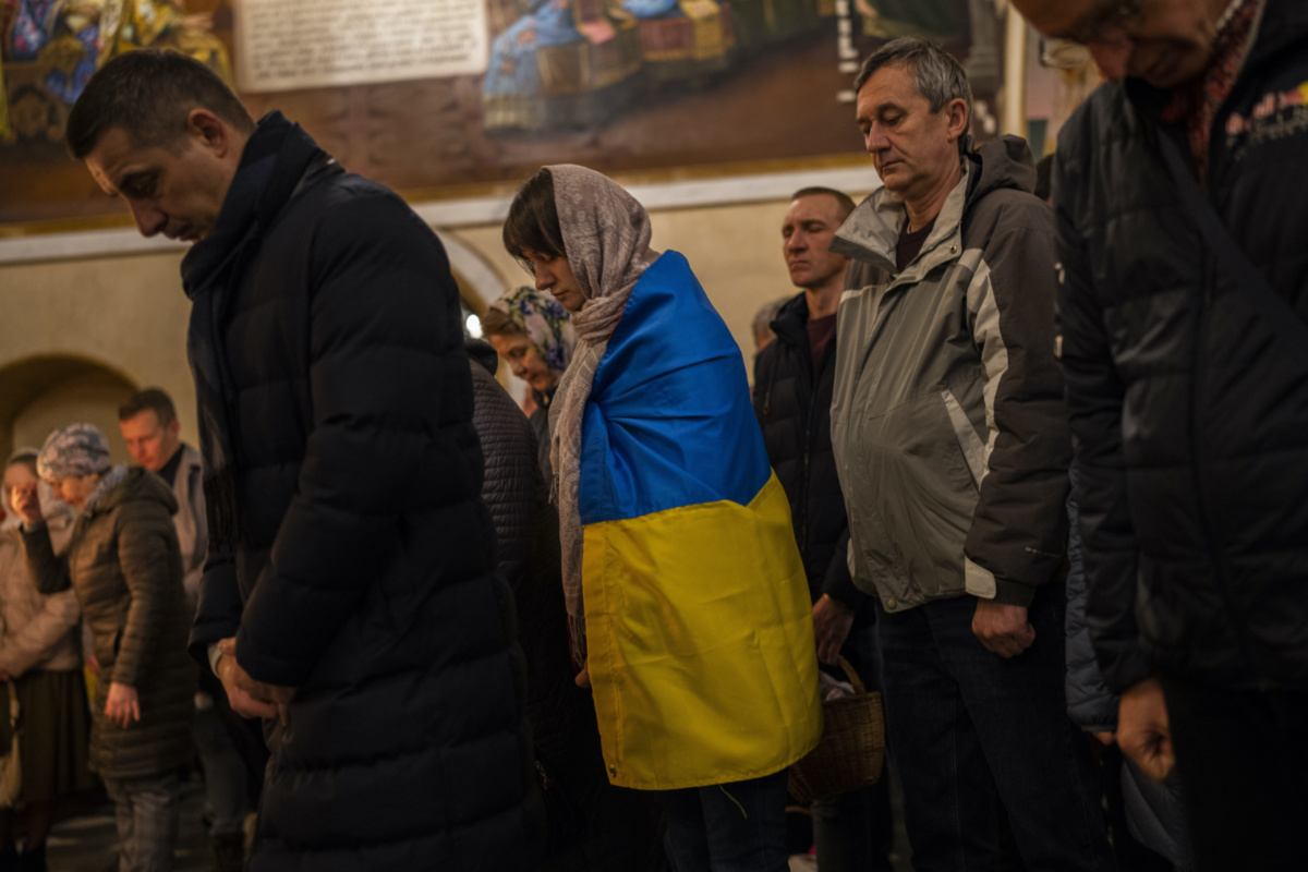 Orthodox Christian worshipper covered with the Ukrainian flag attends an Easter Sunday mass in Kyiv, Sunday, on 16th April, 2023.