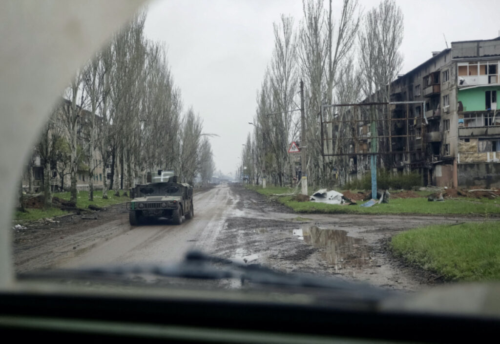 A Ukrainian service member rides a military vehicle near residential buildings damaged by a Russian military strike, amid Russia's attack on Ukraine, in the front line town of Bakhmut, in Donetsk region, Ukraine, on 21st April, 2023.