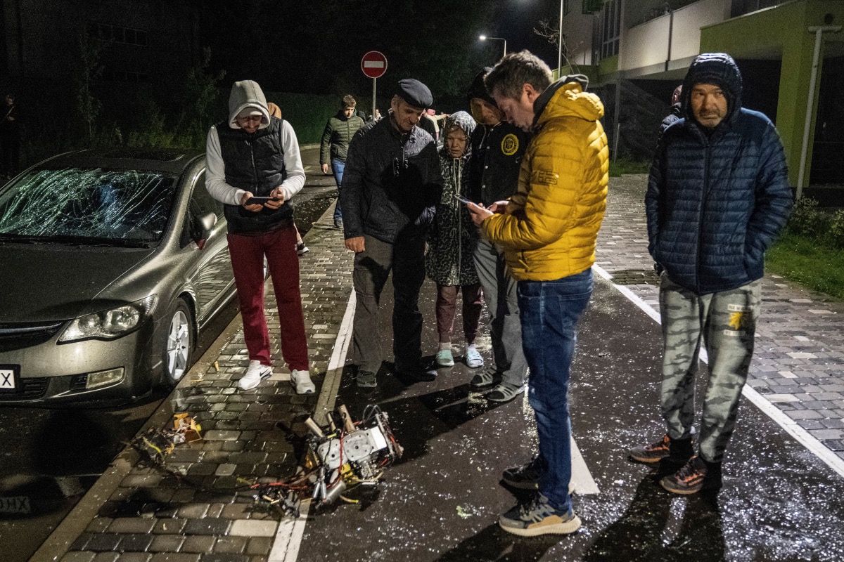 Local residents inspect a part of a suicide drone, which local authorities consider to be Iranian made unmanned aerial vehicles Shahed-131/136, shot down during a Russian overnight strike, amid Russia's attack on Ukraine, in Kyiv, Ukraine, on 8th May, 2023.