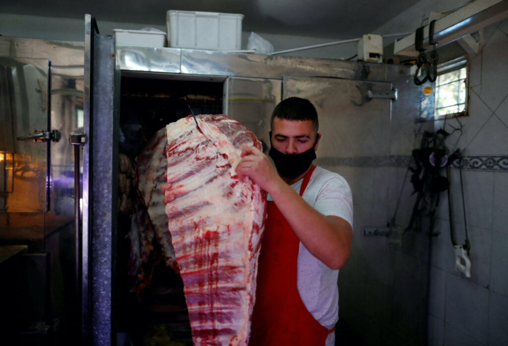 Butcher Pablo Alberto Monzon carries a costillar out of his fridge, at his shop, in General Pacheco, on the outskirts of Buenos Aires, Argentina, on 19th May, 2021.