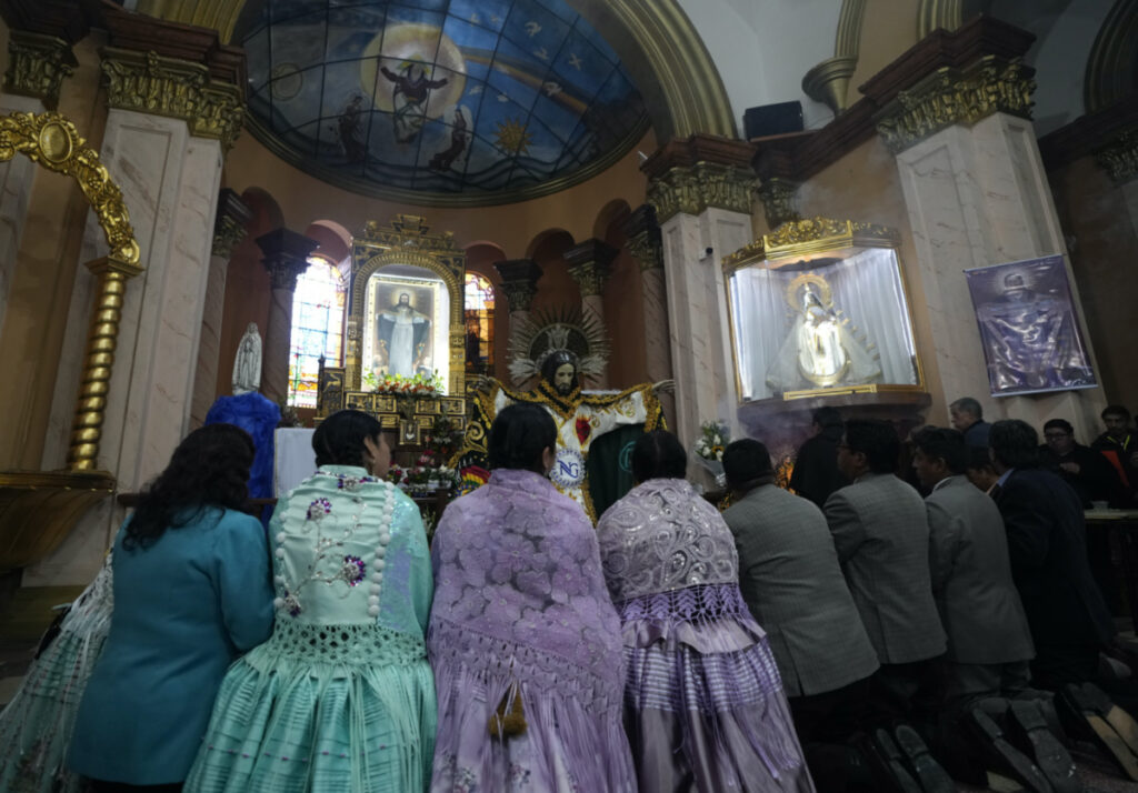 Devotees pray after dressing the statue of "Jesus del Gran Poder" or Lord of Great Power, at the "Jesus del Gran Poder" church in La Paz, Bolivia, on Thursday, 1st June, 2023.