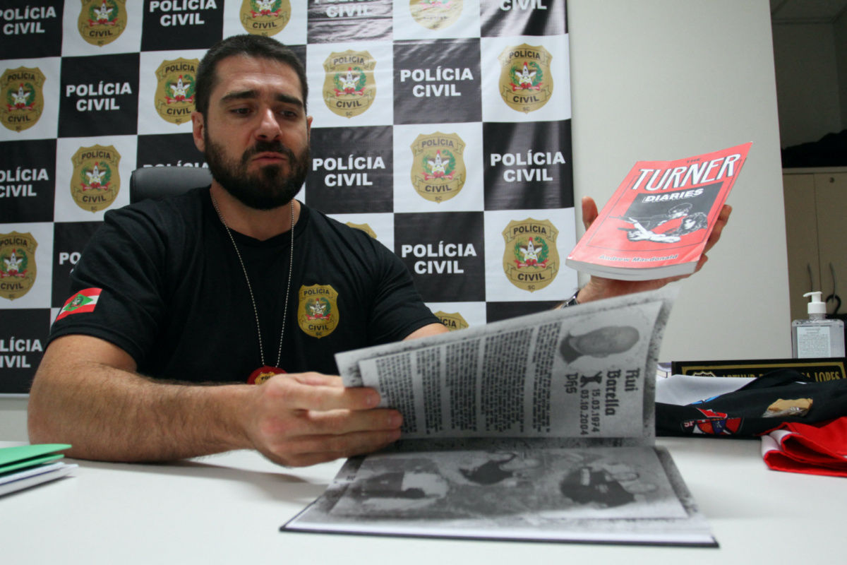 Police detective Arthur Lopes shows books seized from a neo-Nazi group who call themselves Crew 38 in Florianopolis, Santa Catarina state, Brazil, on 24th April, 2023.