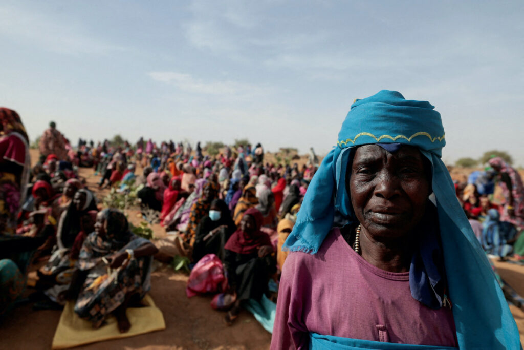 Halime Adam Moussa, a Sudanese refugee who is seeking refuge in Chad for a second time, waits with other refugees to receive a food portion from World Food Programme, near the border between Sudan and Chad in Koufroun, Chad, on 9th May, 2023.
