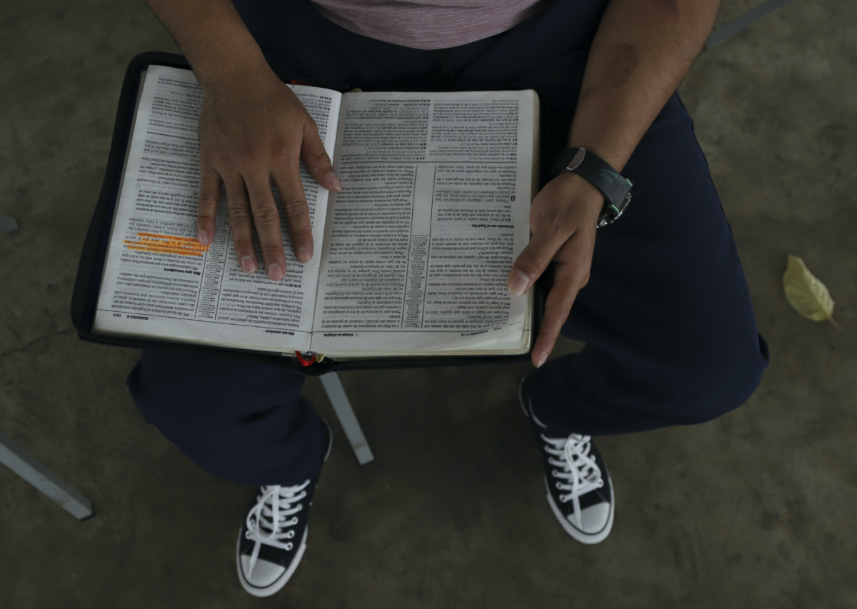 A young man who was imprisoned for belonging to a gang reads a Bible during family visiting hours at the “Vida Libre” or “free life", rehabilitation centre, in Santa Ana, El Salvador, on Saturday, 29th April, 2023. 