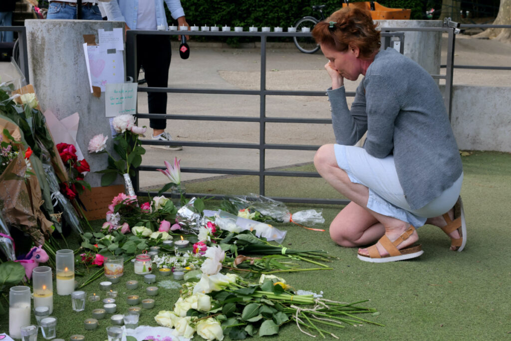 A woman pays respect in front of messages and floral tributes at the children's playground the day after several children and adults were injured in a knife attack at the Le Paquier park near the lake in Annecy, in the French Alps, France, on 9th June, 2023.