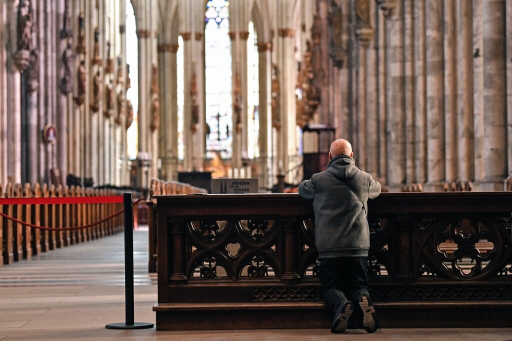 A man prays in the empty world famous Cologne Cathedral in Cologne, Germany, on Sunday, 15th March, 2020.