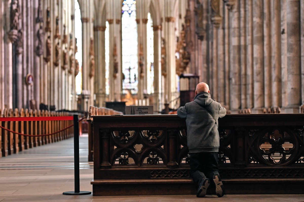 A man prays in the empty world famous Cologne Cathedral in Cologne, Germany, on Sunday, 15th March, 2020. 