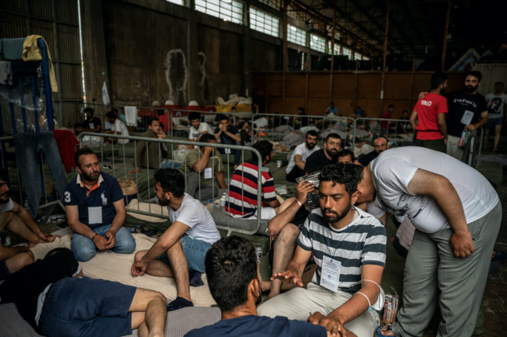 Migrants who were rescued at open sea off Greece along with other migrants, after their boat capsized, are seen inside a warehouse, used as shelter, at the port of Kalamata, Greece, on 15th June, 2023