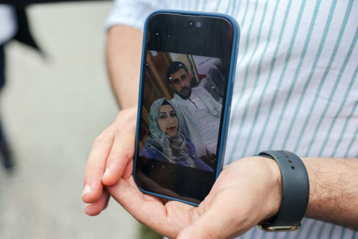 Syrian Kassam Abozeed, 34, who says his wife Israa and brother-in-law were onboard a boat with migrants that capsized at open sea off Greece, shows a photo of him and his wife, at the port of Kalamata, Greece, on 15th June, 2023. 