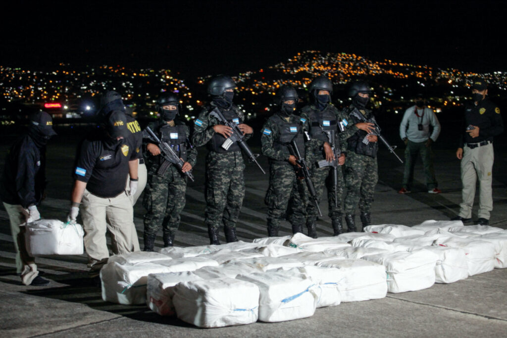Officers of Honduras' Technical Agency for Criminal Investigation carry a package containing cocaine seized during a police operation, at a presentation to the media, in Tegucigalpa, Honduras, on 11th December, 2022.