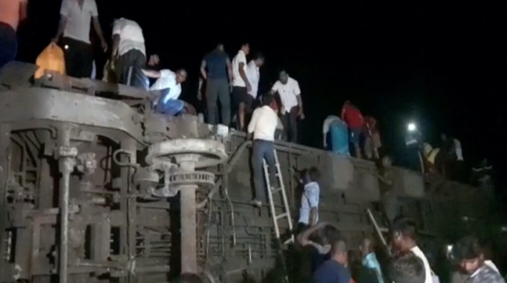 People try to escape from toppled compartments, following the deadly collision of two trains, in Balasore, India on 2nd June, 2023,
