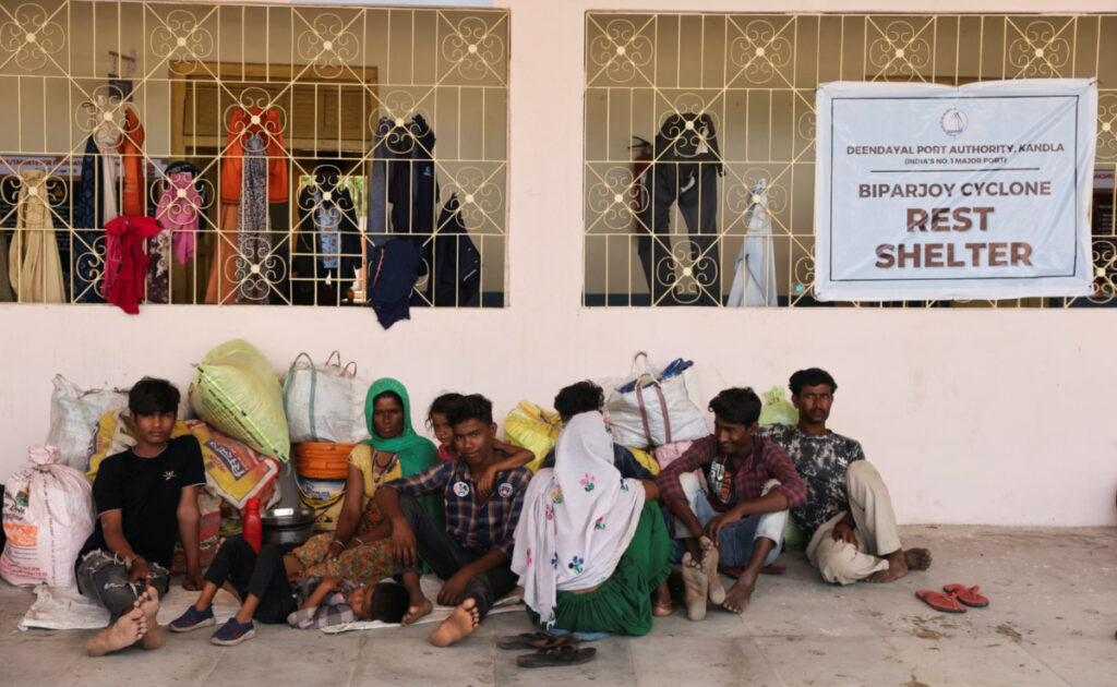 People evacuated from Kandla port sit outside a school converted into a shelter, before the arrival of cyclone Biparjoy, in Gandhidham, in the western state of Gujarat, India, on 13th June, 2023.