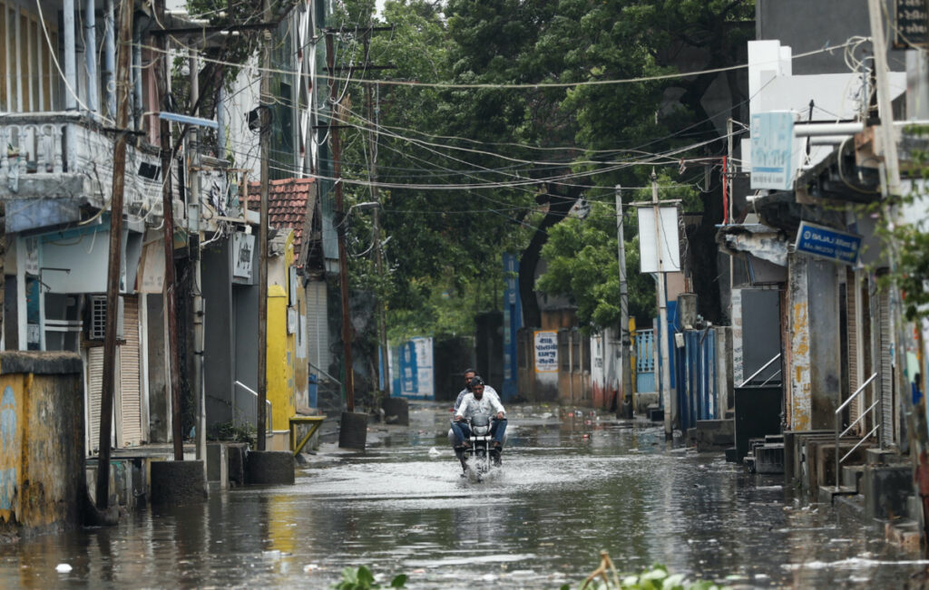A man rides a motorcycle through a waterlogged street in Mandvi before the arrival of cyclone Biparjoy in the western state of Gujarat, India, on 15th June, 2023.