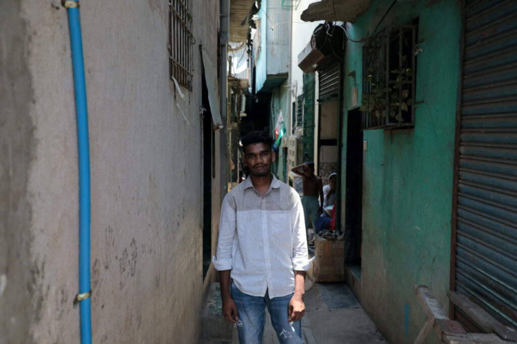 Nizamudin Abdul Rahim Khan, 23, a worker, poses for a photograph in an alley at a slum area in Mumbai, India, on 20th May, 2023.