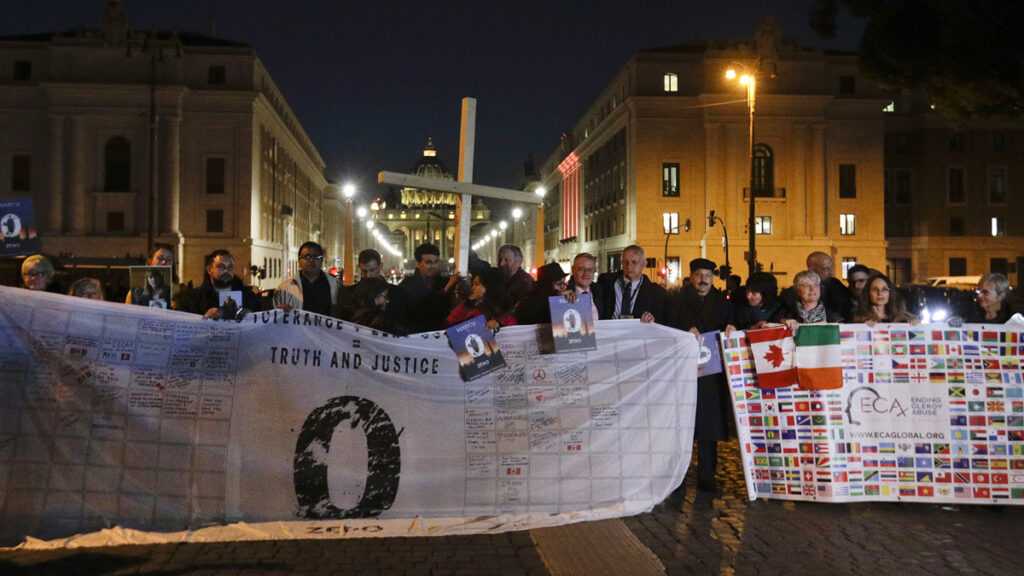 Survivors of sex abuse hold a cross as they gather in front of Via della Conciliazione, the road leading to St Peter's Square, visible in background, during a twilight vigil prayer of the victims of sex abuse, in Rome, on 21st February, 2019.