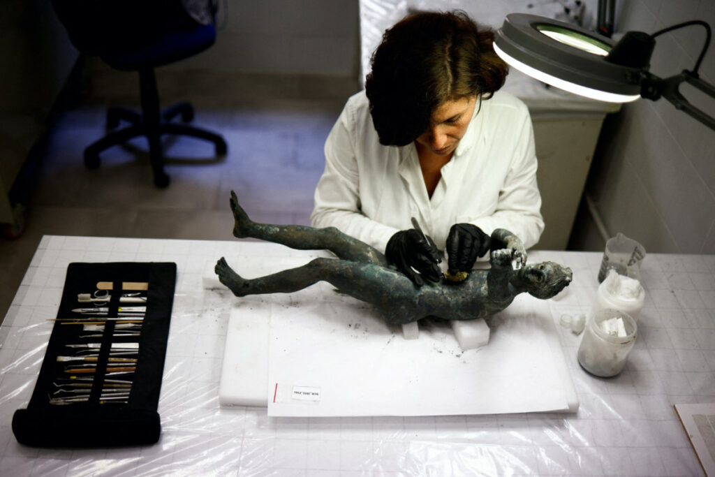 Restorer Laura Rivaroli works on a bronze statue of Apollo in the pose of an archer, after it was discovered and pulled out from the muddy ruins of an ancient spa in San Casciano dei Bagni, a hilltop village in southern Tuscany still home to popular thermal baths, in Grosseto, Italy, on 29th May, 2023.
