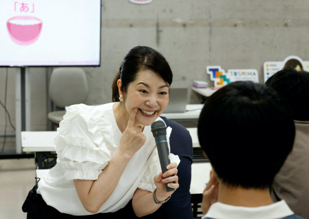 Smile coach Keiko Kawano teaches students at a smile training course at Sokei Art School in Tokyo, Japan, on 30th May, 2023.
