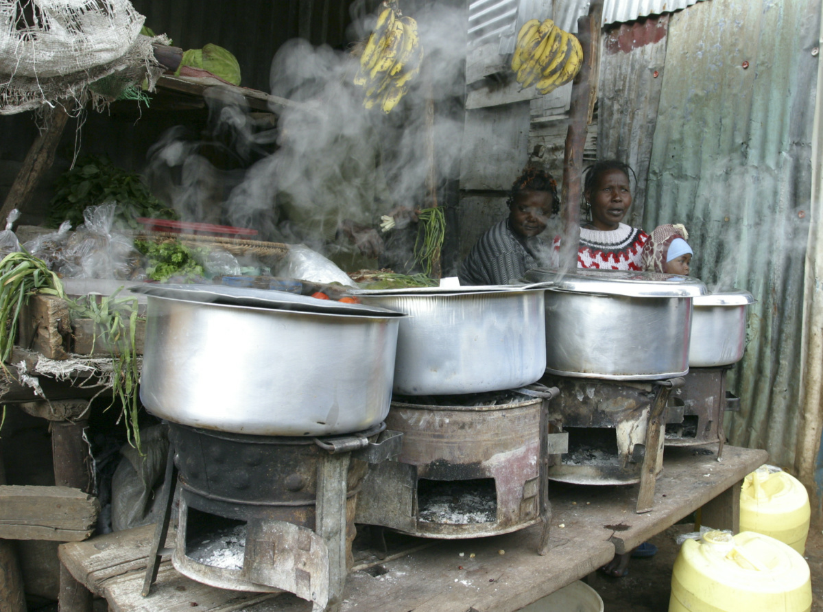 Women sit next to their cooking stoves at the sprawling Kibera slums in Kenya's capital Nairobi, on 8th June, 2009.
