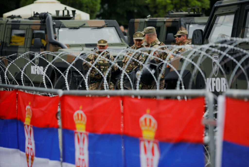Italian members of the NATO-led Kosovo Force stand guard behind wire fencing, in Leposavic, Kosovo, on 1st June, 2023.