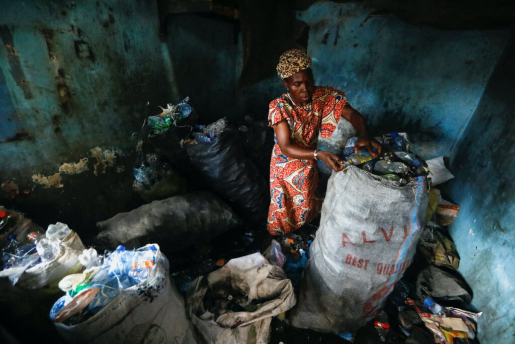 Fatimoh Adeosun, 48, a parent of a student of My Dream Stead, a low-cost school that accepts recyclable wastes as payment, sorts plastic waste for submission, in Ajegunle, Lagos, Nigeria, on 19th May 2023.