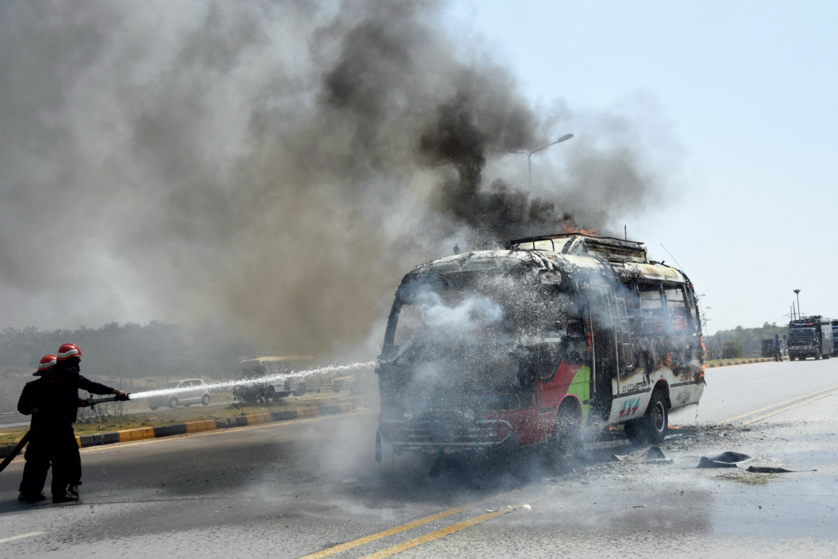 Firefighters try to douse a bus that caught fire during clashes with the supporters of Pakistan's former Prime Minister Imran Khan in Islamabad, Pakistan, on 12th May, 2023