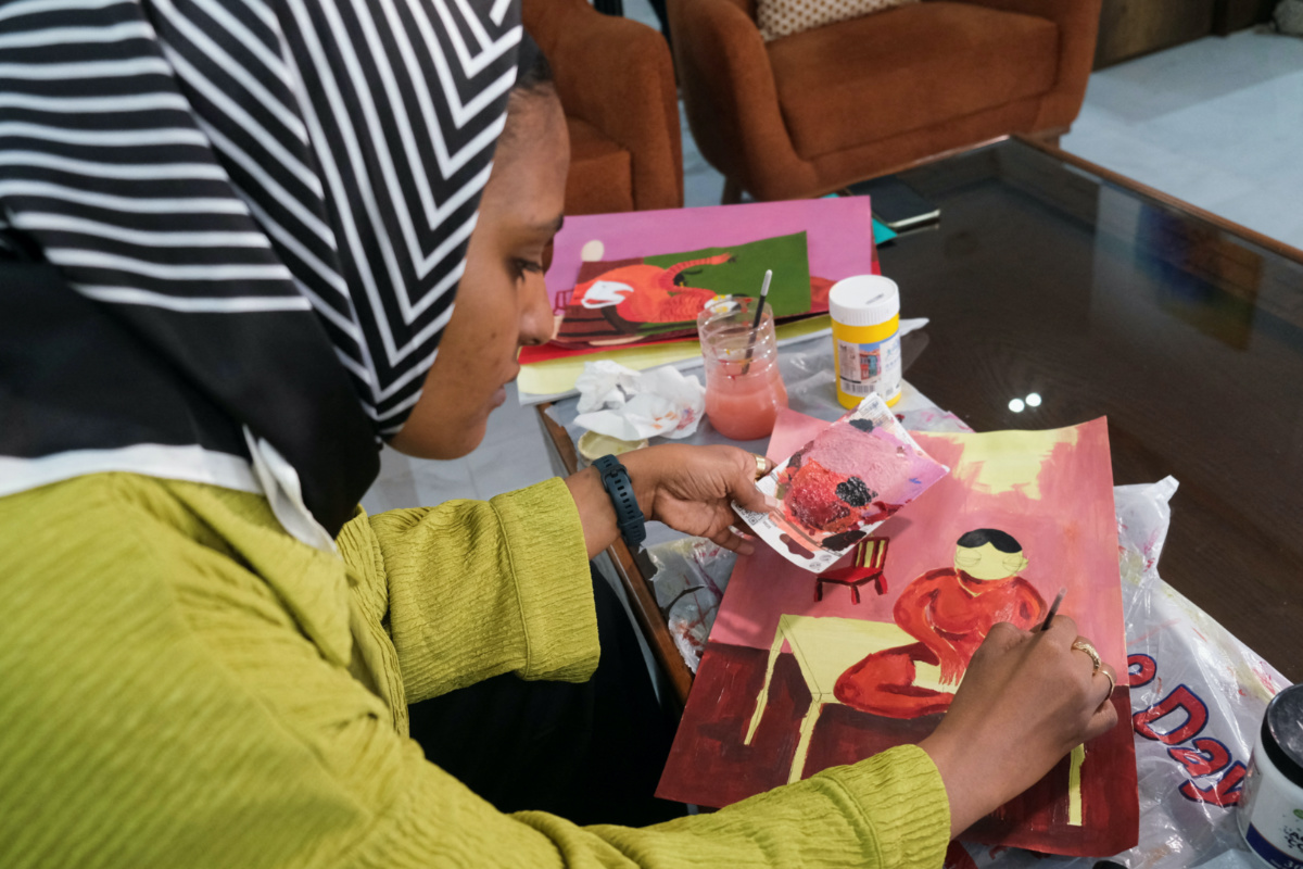 Reem Al Jeally, a Sudanese artist, works on a new painting at her rented house in Cairo, Egypt, on 25th May, 2023.  