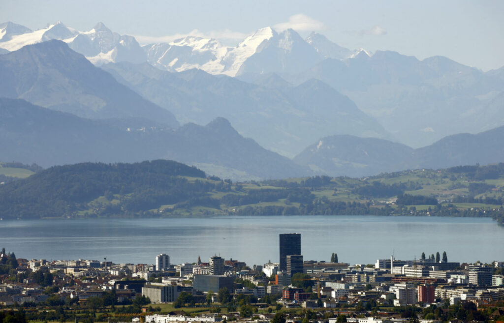 The snow-covered peaks of Bernese Oberland are seen behind Lake Zug and the city of Zug, Switzerland, on 20th August, 2020.