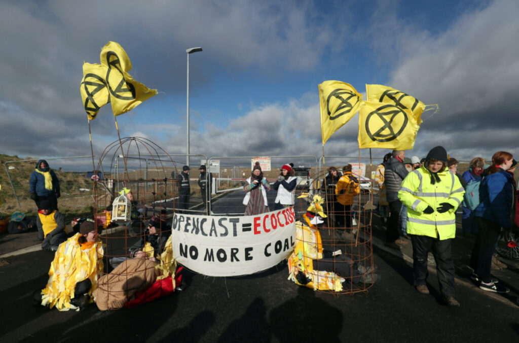 Extinction Rebellion demonstrators sit in structures representing "canary in the coal mine" bird cages as others gather during a protest at Banks Group's open-cast coal mine in Bradley, County Durham, Britain, on 26th February, 2020