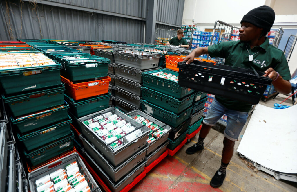 Volunteers at the charity Greenwich Foodbank, Jerald De-Great Aryee and Daniel Kennett-Brown, organise stocks of food before the items are dispatched to benefactors, at a storage facility in London, Britain, on 27th June, 2023.