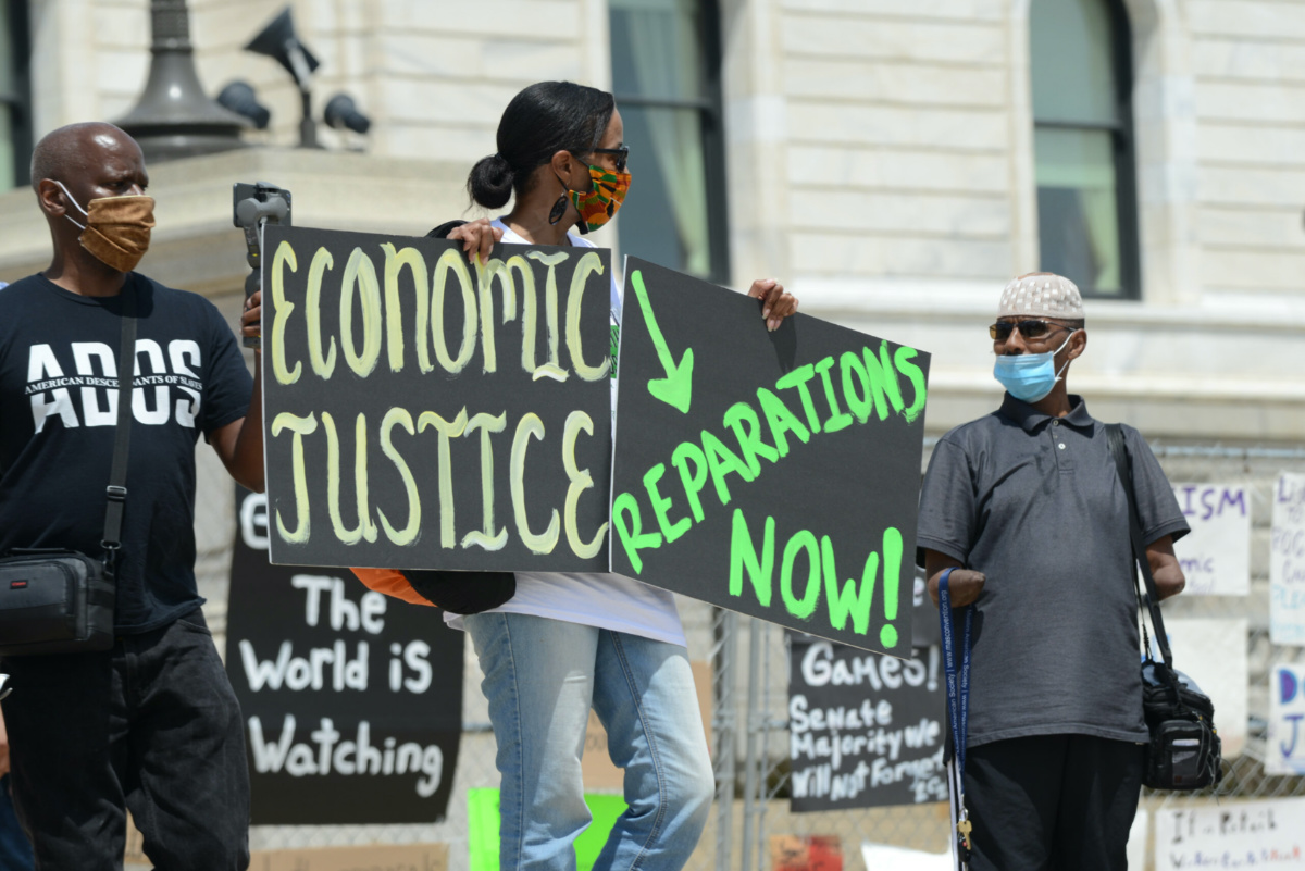 Several hundred people demonstrate outside the Minnesota capitol building to demand reparations from the United States government for years of slavery, Jim Crow, segregation, redlining, and violence against black people from police, on 19th June, 2020, in St Paul, Minnesota. 