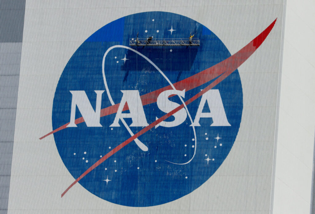 Workers pressure wash the logo of NASA on the Vehicle Assembly Building before SpaceX will send two NASA astronauts to the International Space Station aboard its Falcon 9 rocket, at the Kennedy Space Center in Cape Canaveral, Florida, US, on 19th May 19, 2020.