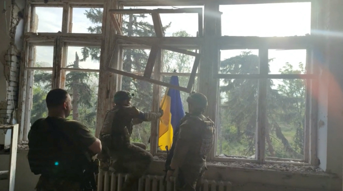 Ukrainian soldiers place a Ukrainian flag at a building, during an operation that claims to liberate the first village amid a counter-offensive, in a location given as Blahodatne, Donetsk Region, Ukraine, in this screengrab taken from a handout video released on 11th June, 2023.