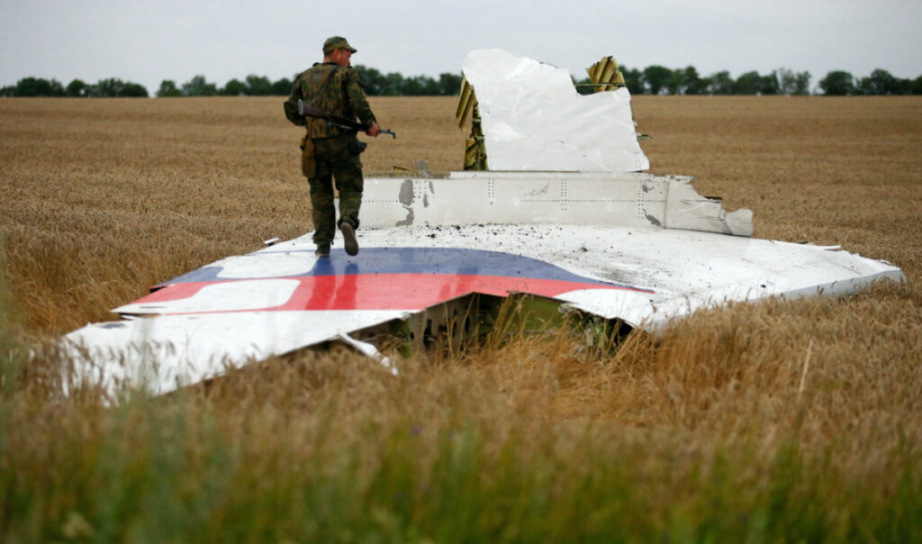 An armed pro-Russian separatist stands on part of the wreckage of the Malaysia Airlines Boeing 777 plane after it crashed near the settlement of Grabovo in the Donetsk region, on 17th July, 2014