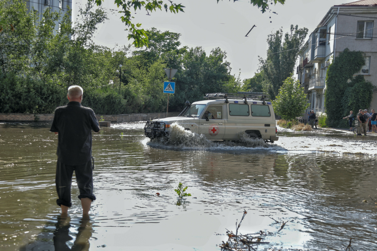 Red Cross volunteers drive a car on a flooded street after the Nova Kakhovka dam breached, amid Russia's attack on Ukraine, in Kherson, Ukraine, on 6th June, 2023. 