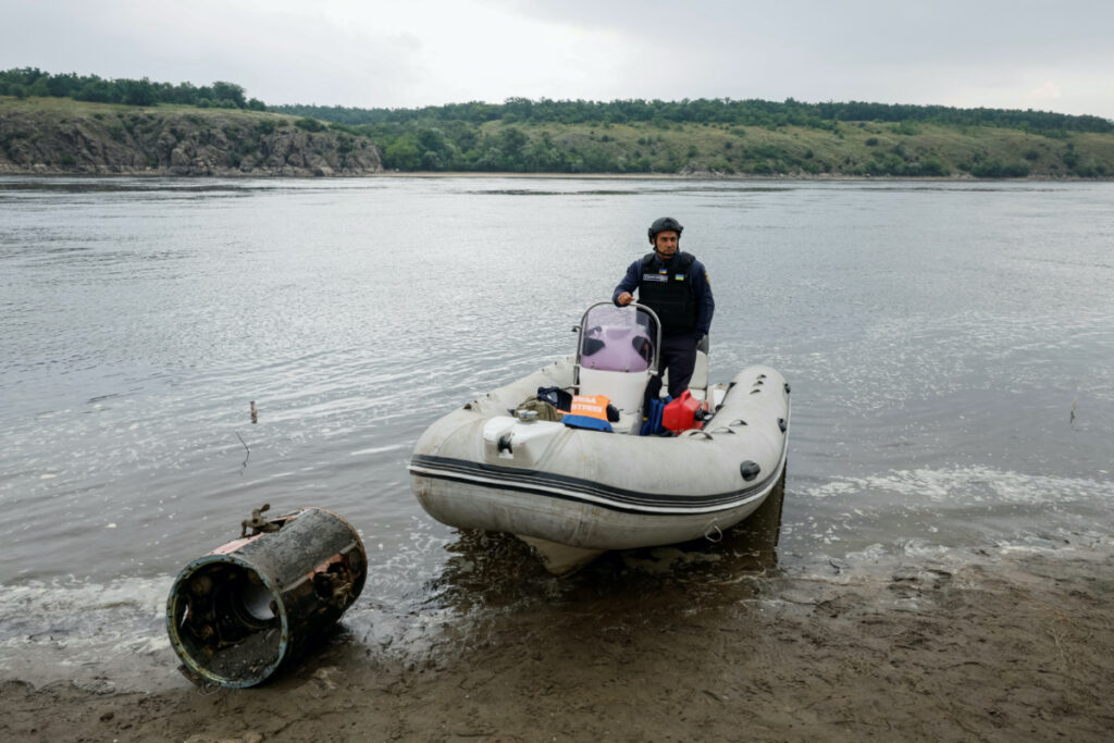 A deminer stands in a boat next to the wreckage of an S-300 rocket, which fell a few months ago in the Dnipro river and became visible after water level sharply dropped following the Kakhovka dam destruction, amid Russia's attack on Ukraine, in Zaporizhzhia, Ukraine, on 12th June, 2023