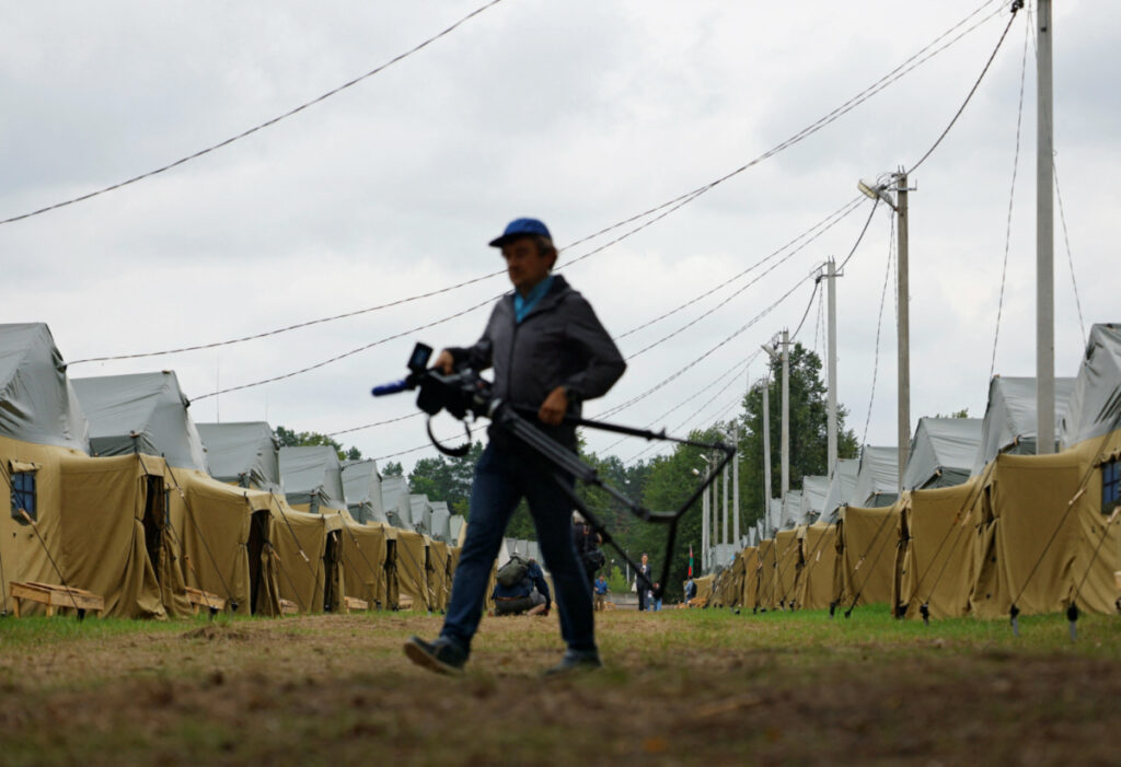 A journalist walks in a tent camp, which, according to the Belarusian Defence Ministry, was set up for exercises at a disused military base near the village of Tsel in the Asipovichy District, Belarus, on 7th July, 2023.