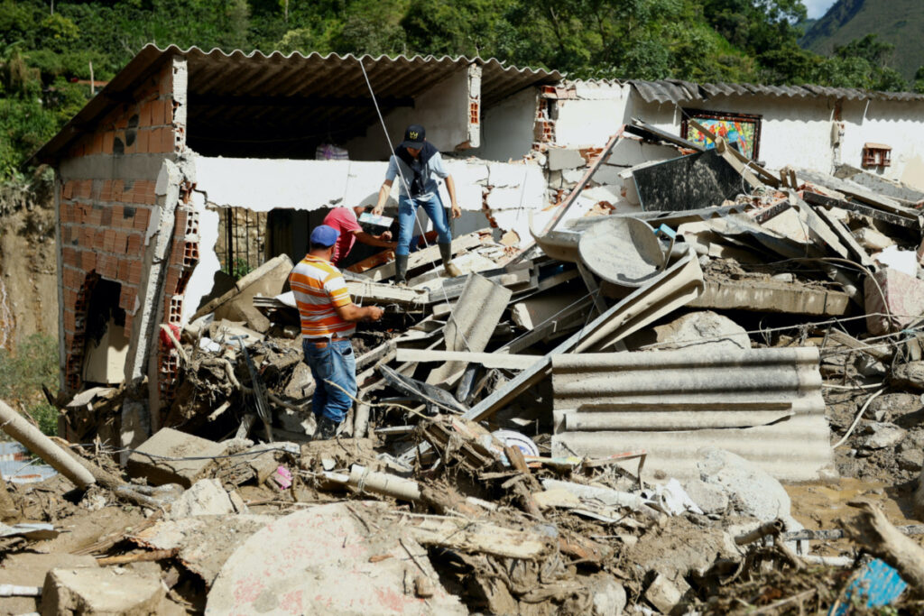 Residents recover their belongings from a house damaged by a landslide which left several casualties and others injured, in Quetame, Colombia, on 18th July, 2023.