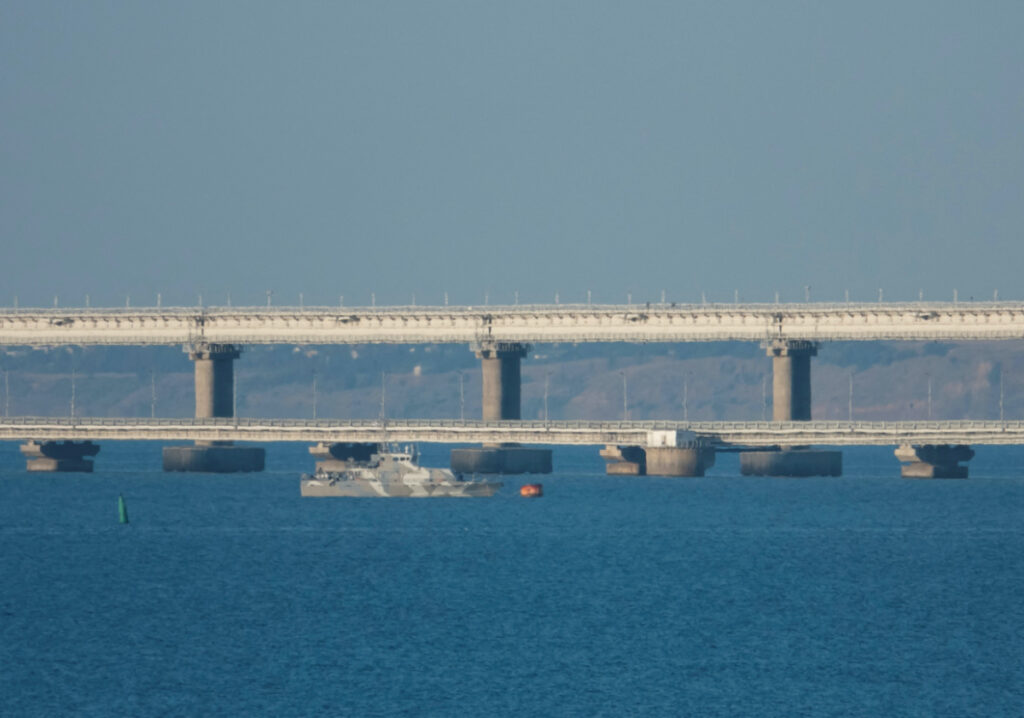 An armed ship sails next to Crimean bridge connecting the Russian mainland with the peninsula across the Kerch Strait, Crimea, on 17th July, 2023.