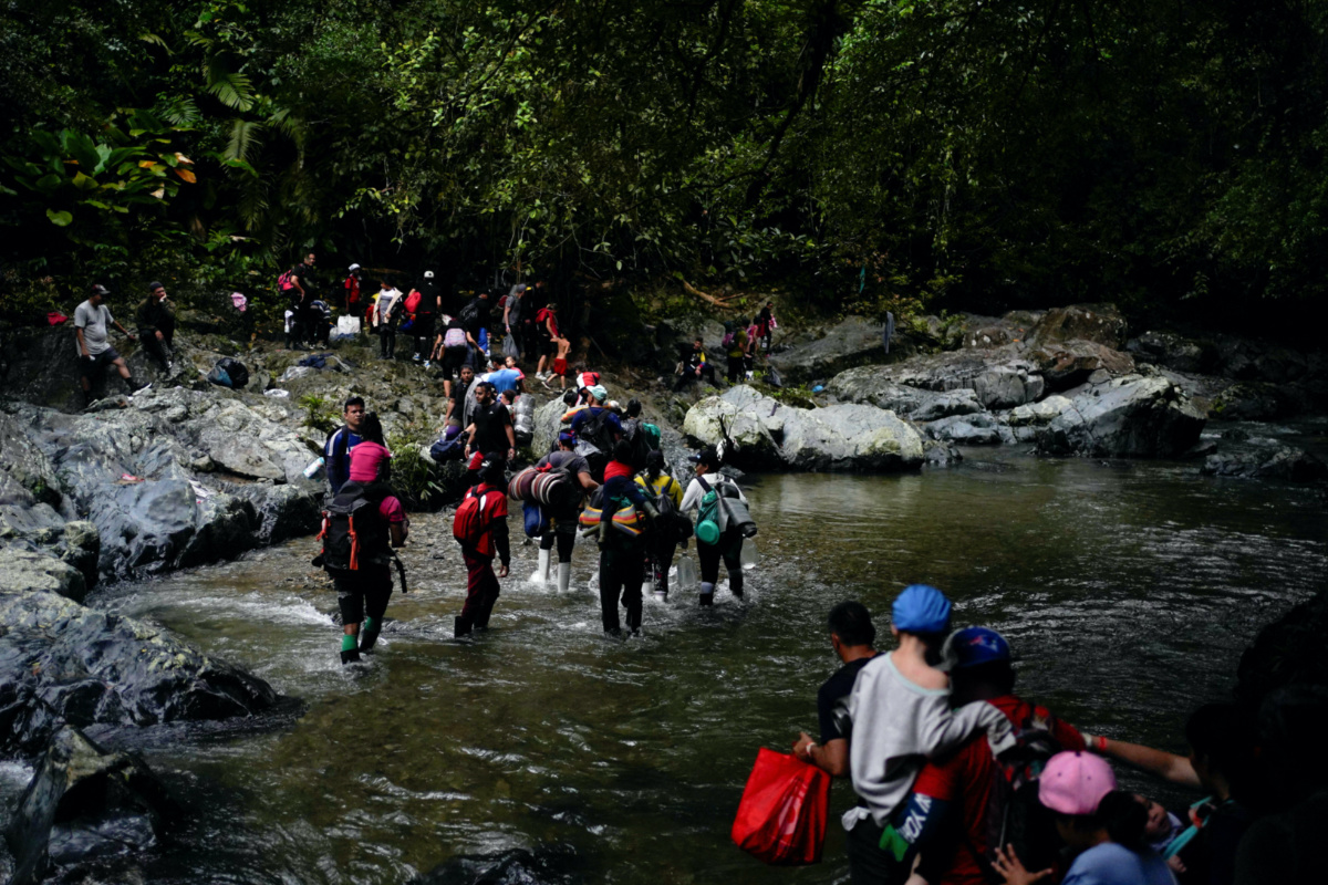 A group of migrants from Venezuela, Ecuador and Haiti cross the Rio Muerto river in the Darien Gap, as they continue their journey to the US border, in Acandi, Colombia, on 9th July, 2023. 