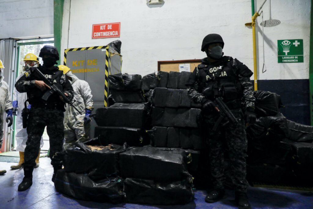 Police officers keep watch next to sacks containing cocaine packages before the incineration of more than nine tons of cocaine seized during different operations, according to the Ecuador's Interior Ministry, in a warehouse at an undisclosed location, in Ecuador, on 21st April 2022.