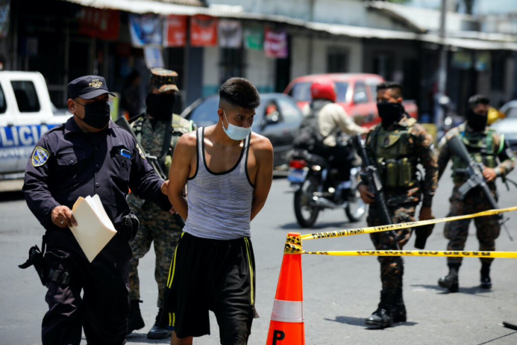 Police officers and soldiers escort a young man to a detention centre, in San Salvador, El Salvador, on 2nd May, 2022.