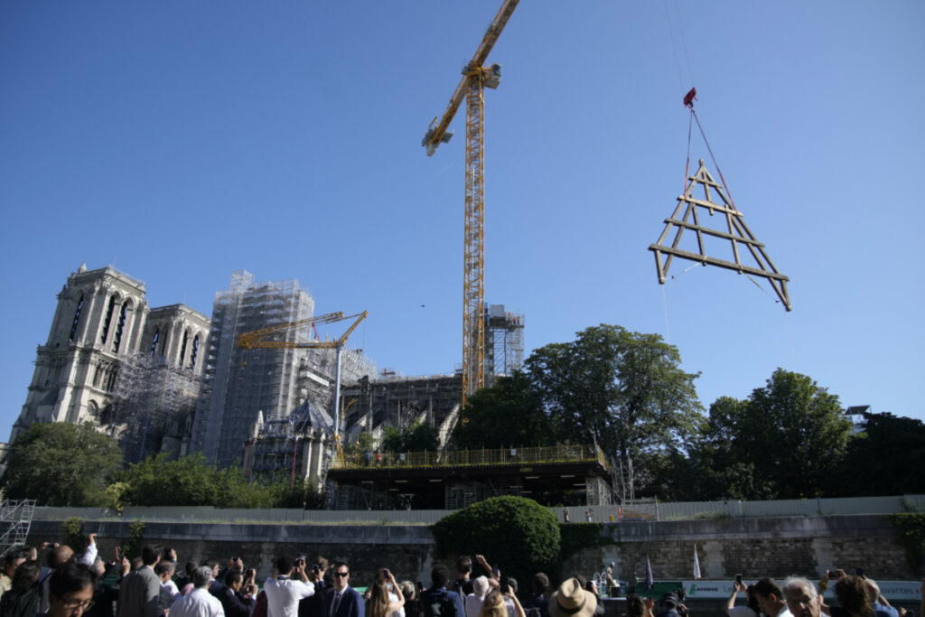 A crane lifts a huge oak frame at Notre Dame de Paris cathedral, on Tuesday, 11th July, 2023 in Paris.