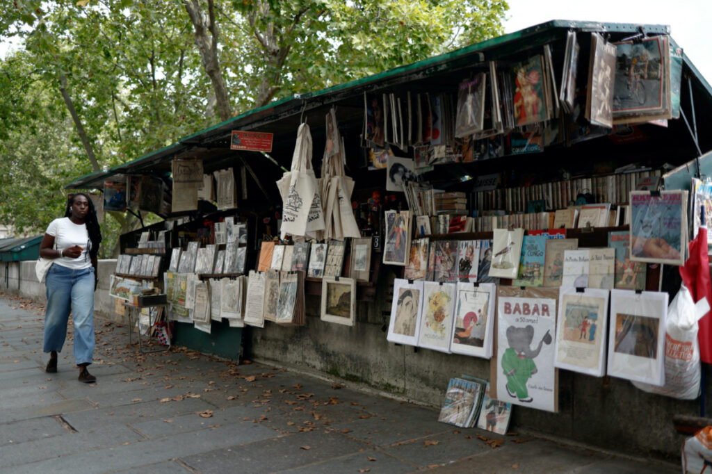 A person walks past a bookseller called Bouquinistes stalls along the banks of the River Seine in Paris, France, on 29th July, 2023.
