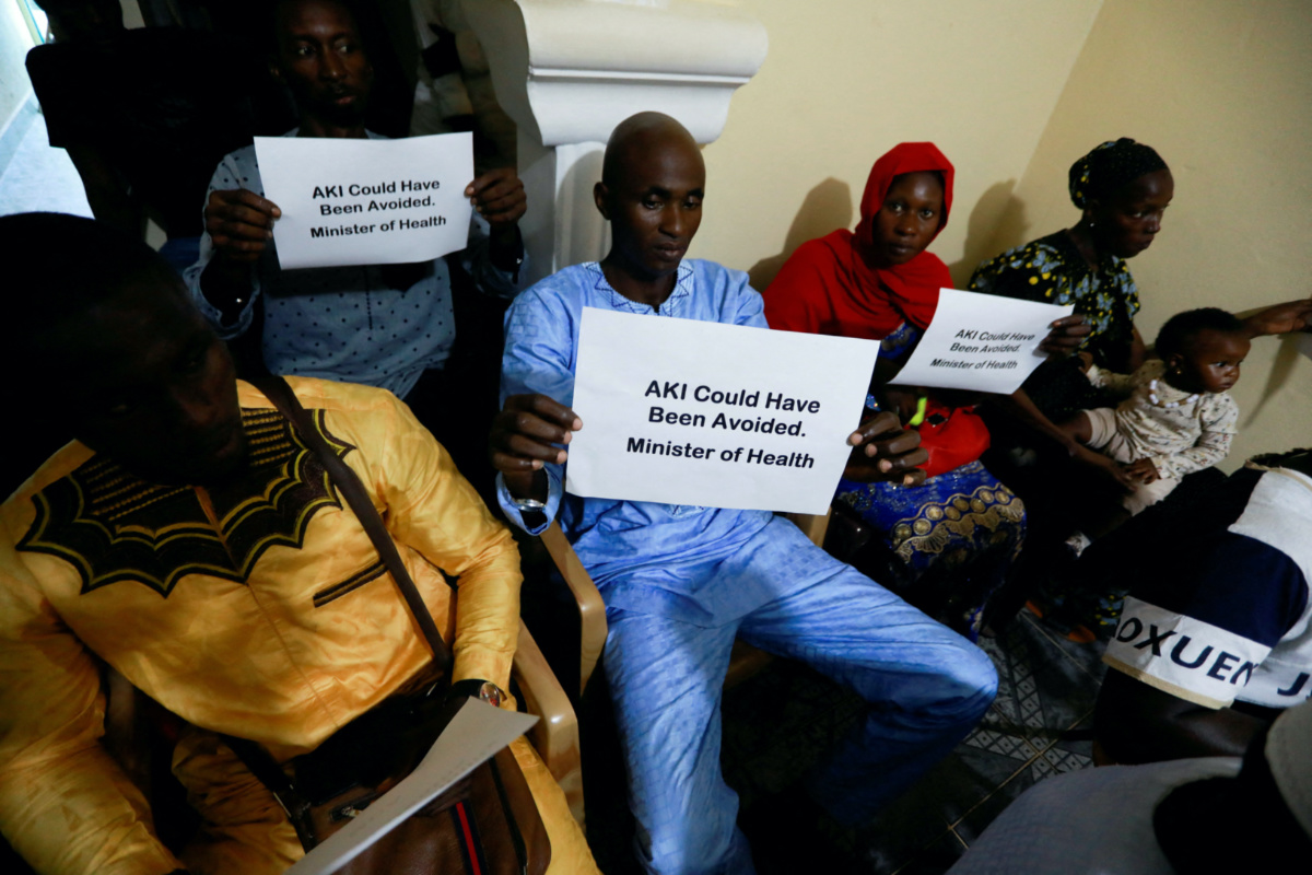 Ebrima Sagnia holds up a sign during a news conference, calling for justice for the deaths of children linked to contaminated cough syrups, in Serekunda, Gambia, on 4th November, 2022. 