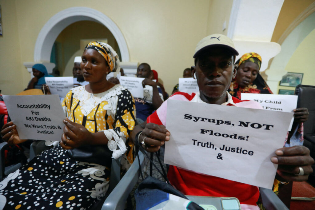 Grieving parents hold up signs during a news conference, calling for justice for the deaths of children linked to contaminated cough syrups, in Serekunda, Gambia, on 4th November, 2022.